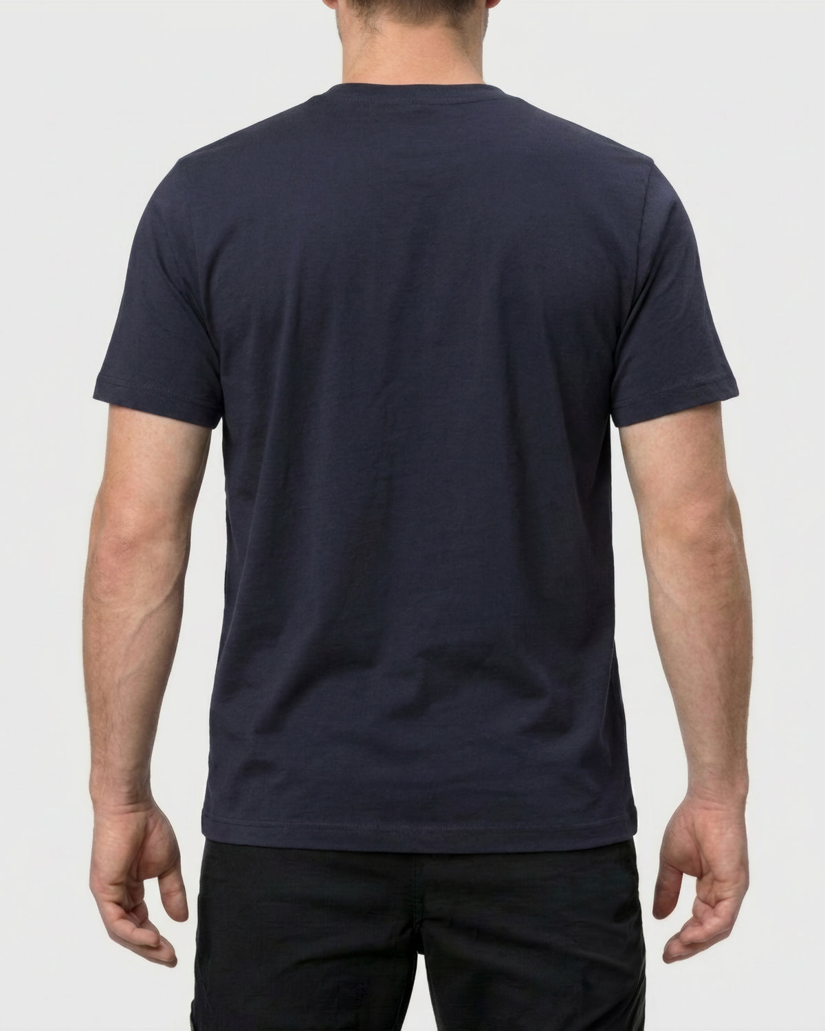 A model wears the STRAUSS Pocket T-Shirt e.s.iconic in nero blue with work pants and work boots, showing the shirt fit