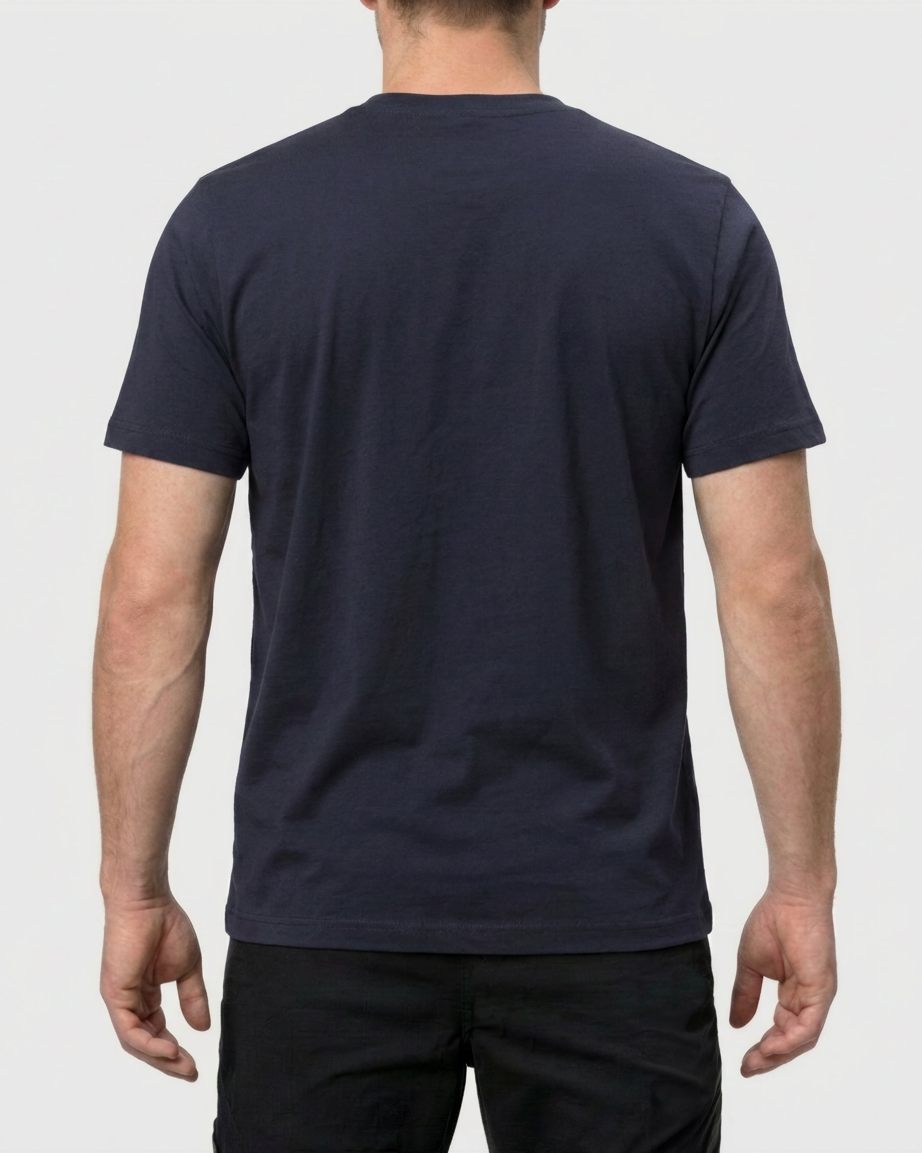 A model wears the STRAUSS Pocket T-Shirt e.s.iconic in nero blue with work pants and work boots, showing the shirt fit