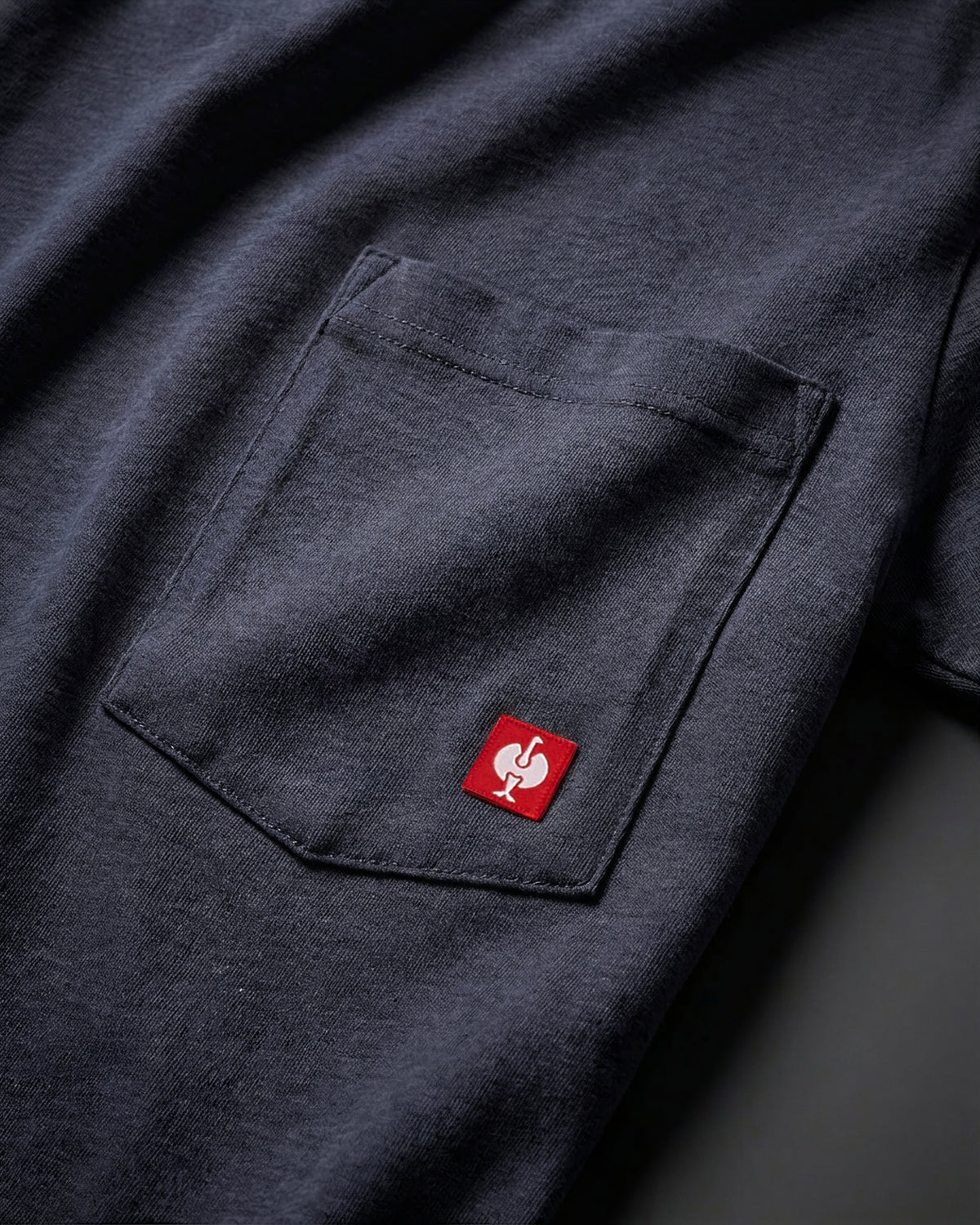 Close-up of the nero blue STRAUSS Pocket T-Shirt e.s.iconic chest pocket with STRAUSS ostrich logo