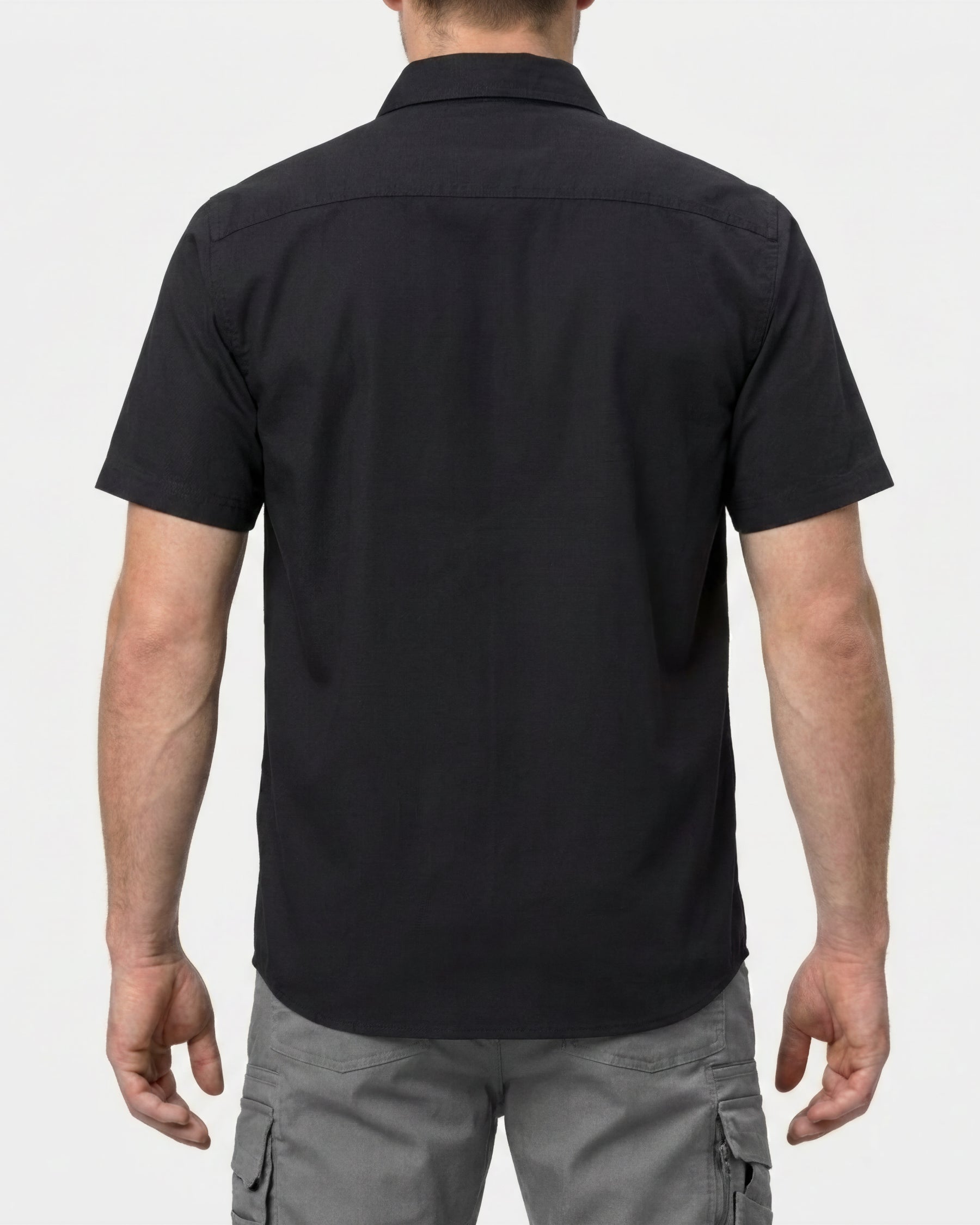 A model wears the STRAUSS Short Sleeve Work Shirt e.s.iconic in black with work pants, showing the shirt fit
