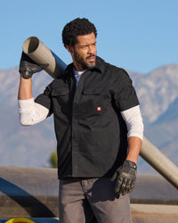 A worker wears the STRAUSS Short Sleeve Work Shirt e.s.iconic in black at a construction site
