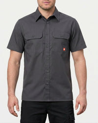A model wears the STRAUSS Short Sleeve Work Shirt e.s.iconic in carbon gray with work pants in a studio product scene