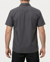 A model wears the STRAUSS Short Sleeve Work Shirt e.s.iconic in carbon gray with work pants