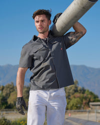 A worker wears the STRAUSS Short Sleeve Work Shirt e.s.iconic in carbon gray at a construction site
