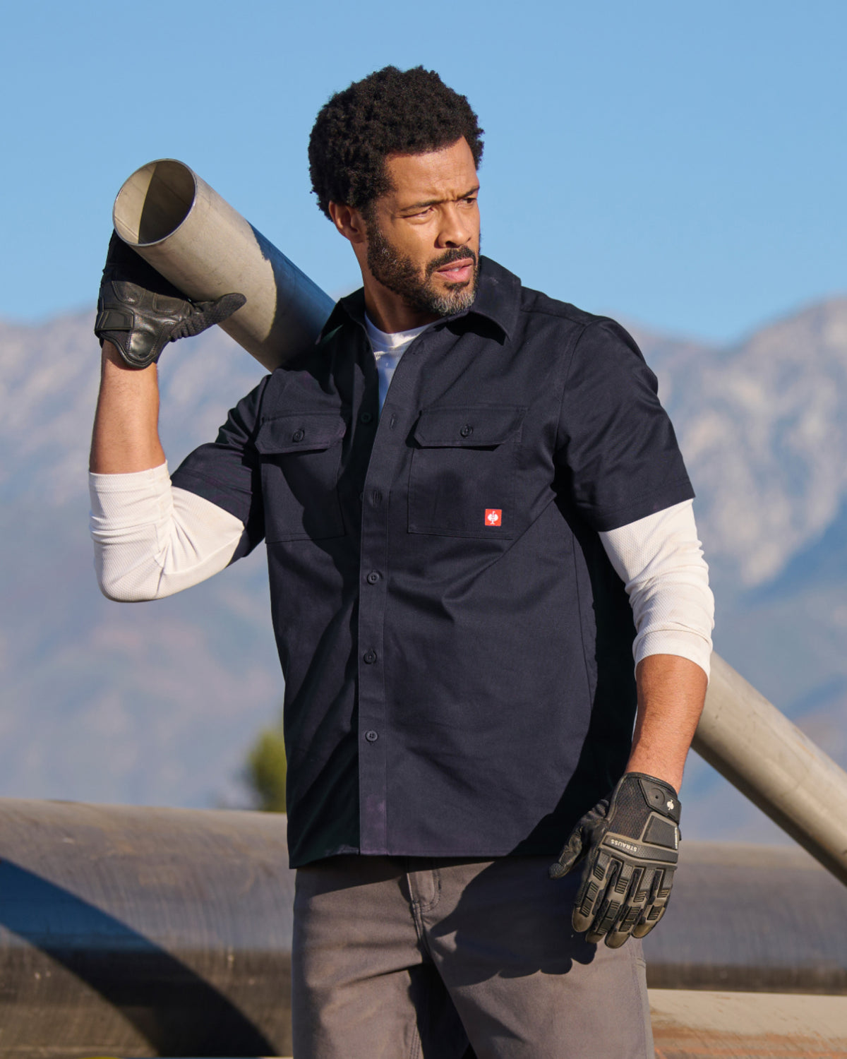 A worker wears the STRAUSS Short Sleeve Work Shirt e.s.iconic in nero blue at a construction site