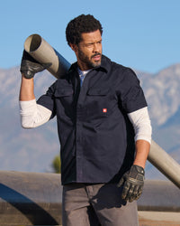 A worker wears the STRAUSS Short Sleeve Work Shirt e.s.iconic in nero blue at a construction site