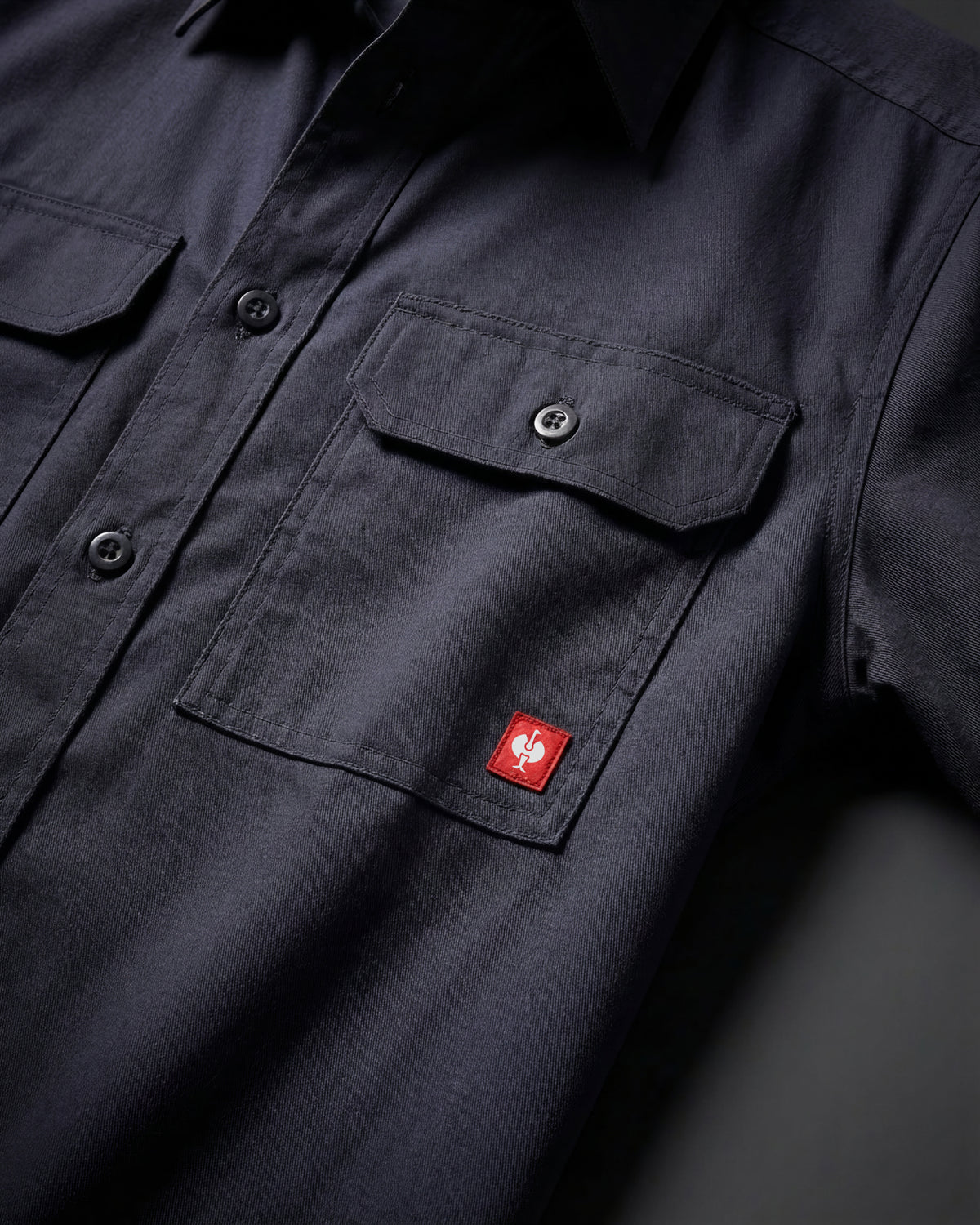 Close-up of the nero blue STRAUSS Short Sleeve Work Shirt e.s.iconic buttoned chest pocket and logo patch