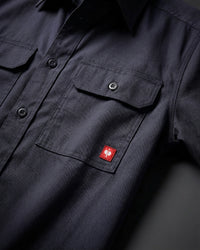 Close-up of the nero blue STRAUSS Short Sleeve Work Shirt e.s.iconic buttoned chest pocket and logo patch