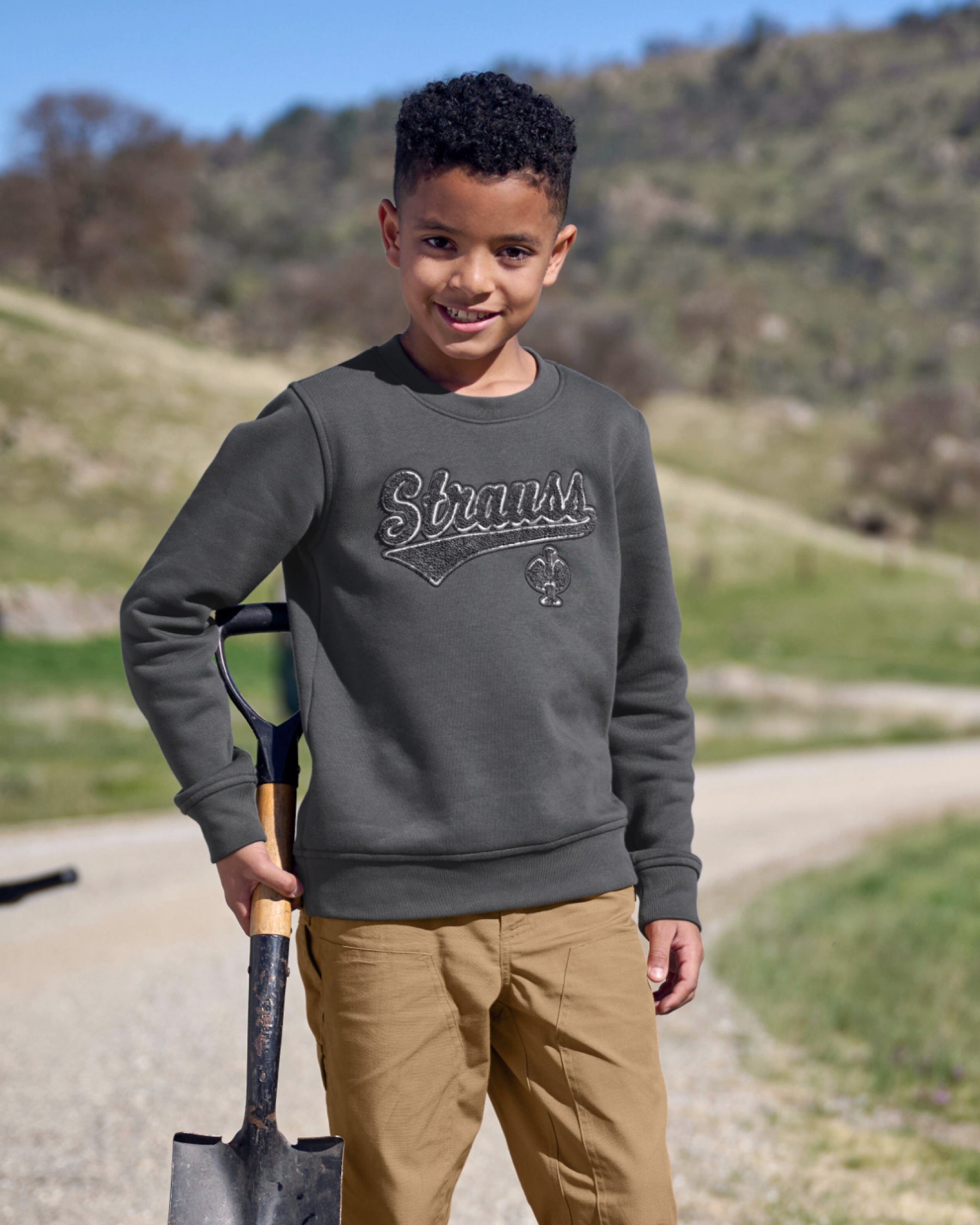 Kids' STRAUSS e.s.e:pic artwork crew neck sweatshirt in carbon gray, worn in lifestyle setting