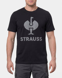 A model wears the STRAUSS T-Shirt e.s.concrete in black with work pants and work boots in a studio product scene