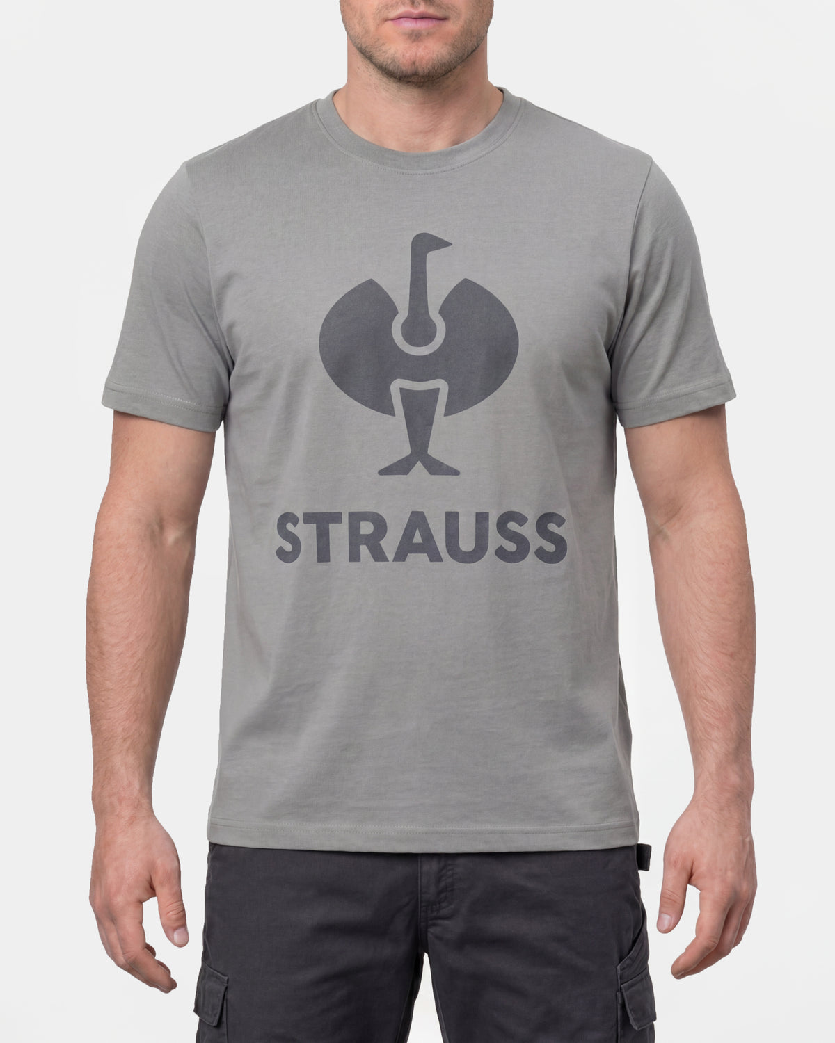 A model wears the STRAUSS T-Shirt e.s.concrete in pearl gray with work pants and work boots in a studio product scene