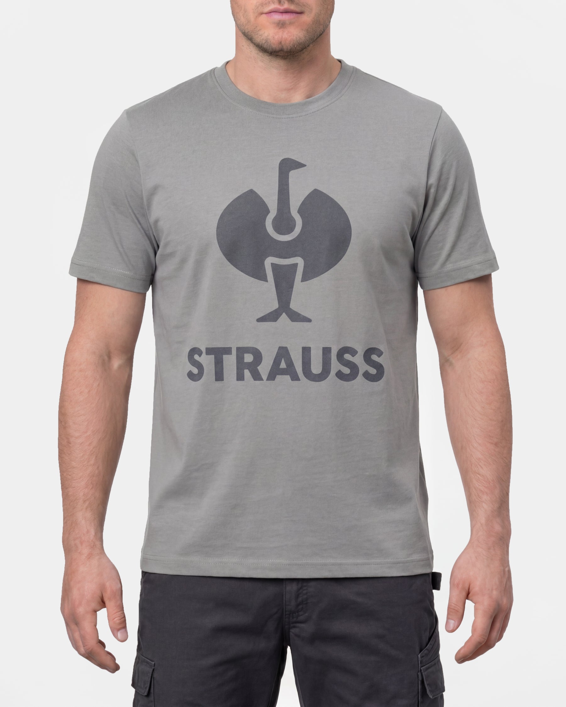 A model wears the STRAUSS T-Shirt e.s.concrete in pearl gray with work pants and work boots in a studio product scene