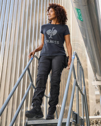A woman wears the Women's STRAUSS T-Shirt e.s.concrete in black with matching work pants in a monochrome workwear outfit
