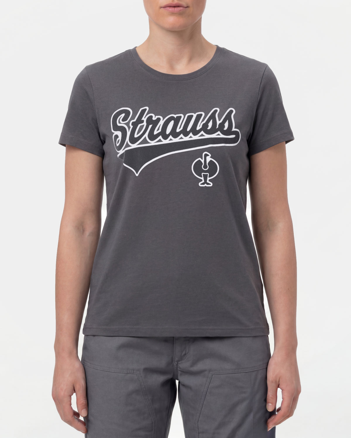 A woman wears the Women's STRAUSS Artwork T-Shirt e.s.e:pic in carbon gray with work pants and work boots in a studio product scene