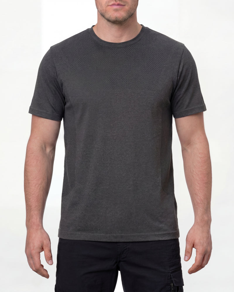A model wears the STRAUSS Seamless Tee e.s.trail pure in black melange with work gloves and work pants in a studio product scene