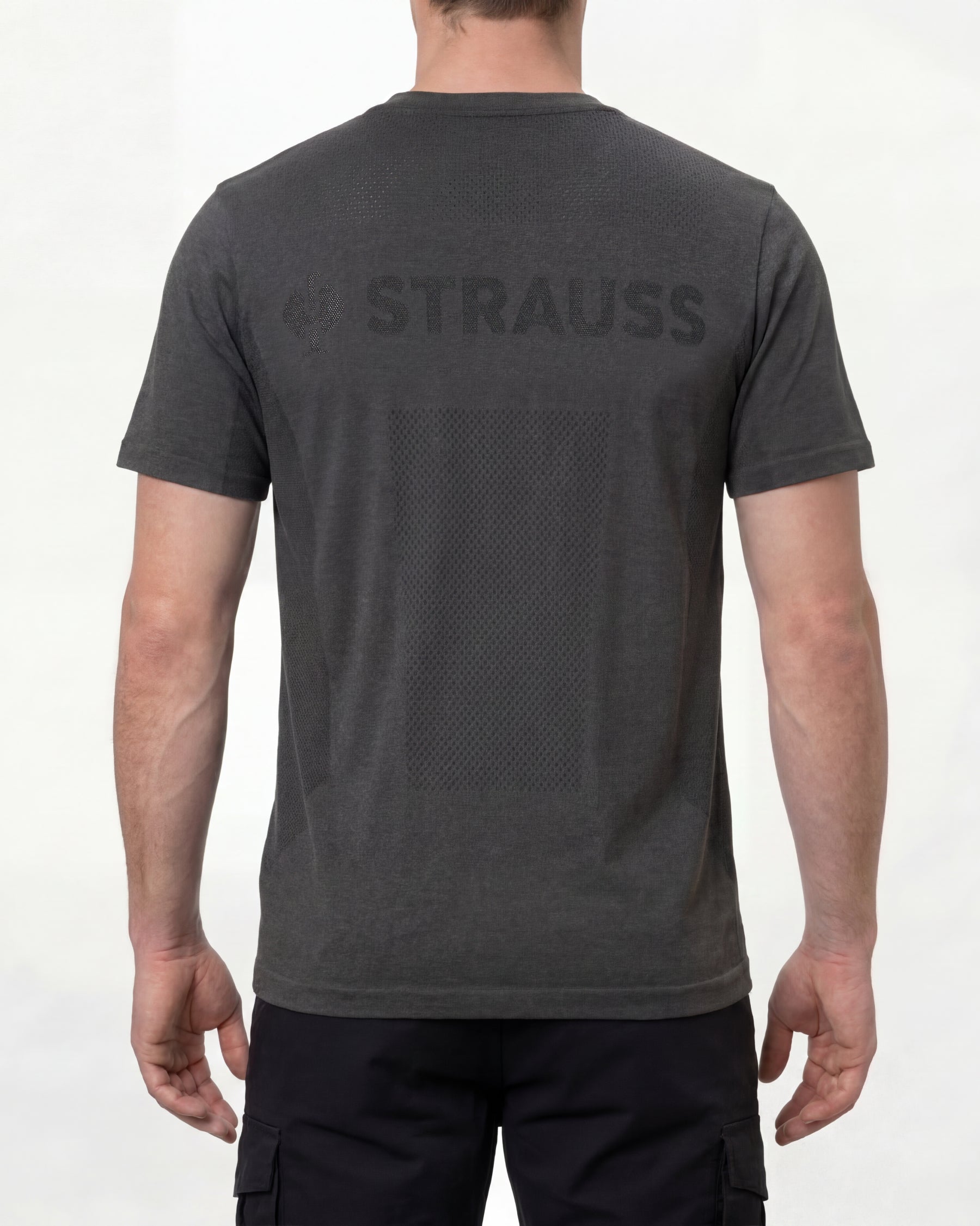A model wears the STRAUSS Seamless Tee e.s.trail pure in black melange with work gloves and work pants, showing the shirt fit