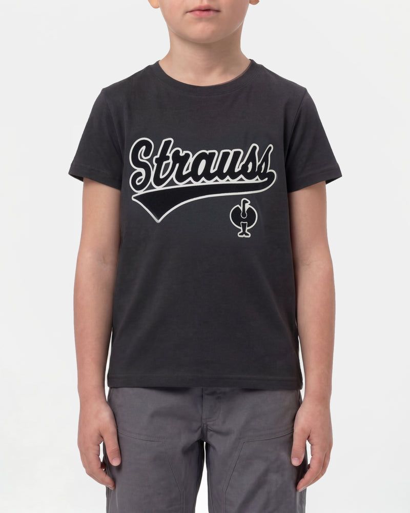 A child wears the Kids' STRAUSS Artwork T-Shirt e.s.e:pic in black with casual workwear pants in a studio product scene