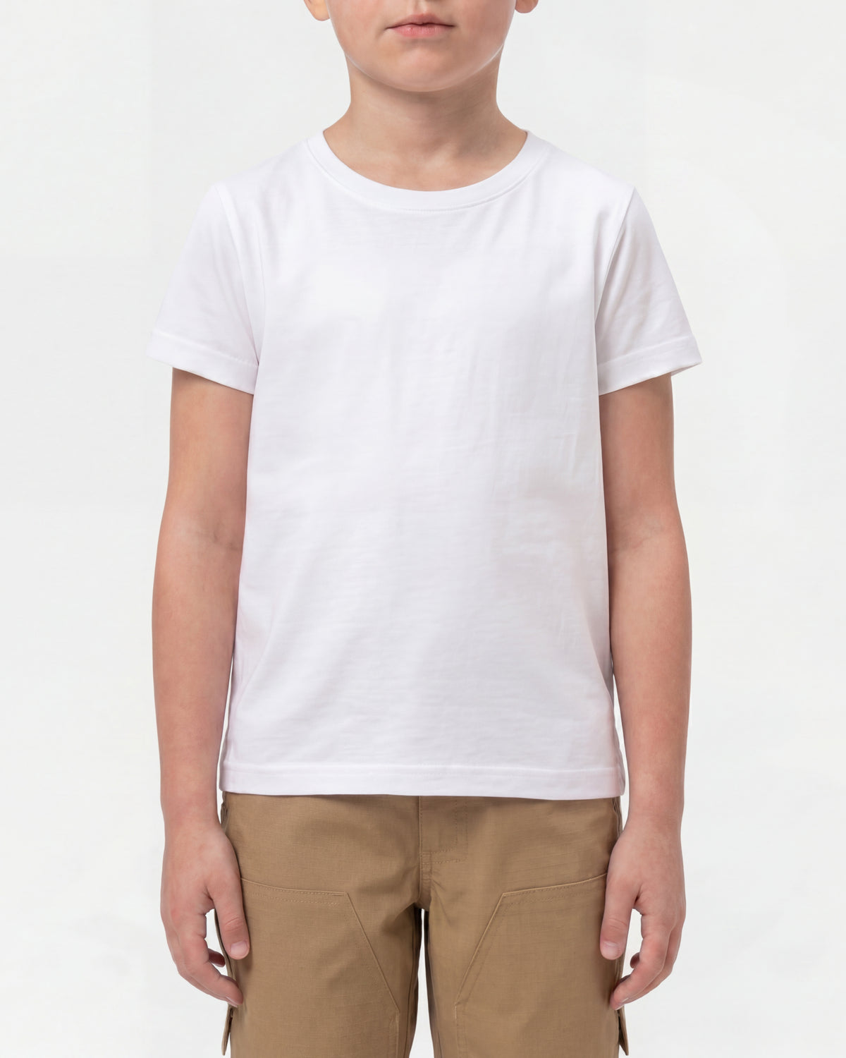 A kid wears the Kids' STRAUSS Cotton Stretch T-Shirt in white with kids' work pants in a studio product scene