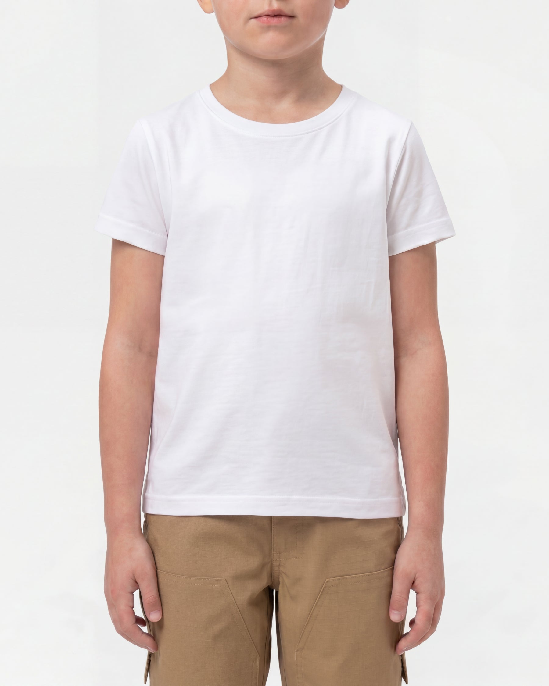 A kid wears the Kids' STRAUSS Cotton Stretch T-Shirt in white with kids' work pants in a studio product scene