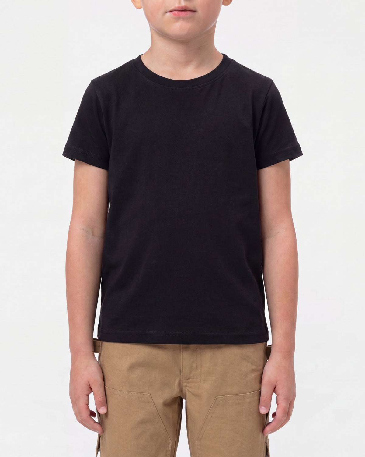 A child model wears the Kids' STRAUSS Cotton Stretch T-Shirt in black with kids' work pants and work boots in a studio product scene