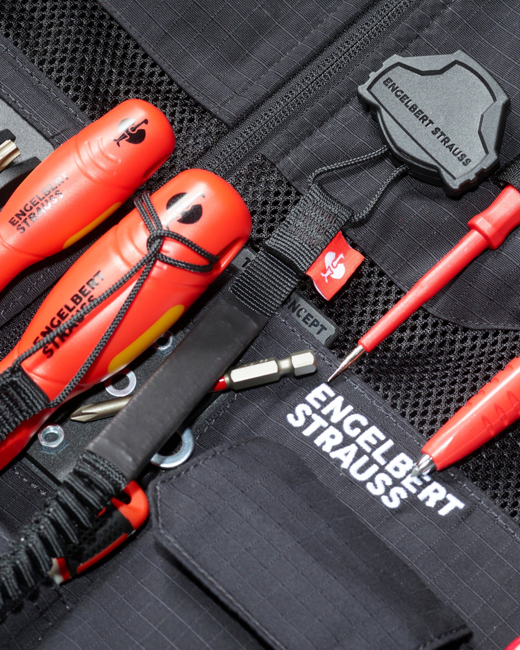 A worker uses a black STRAUSS e.s.tool concept tool leash on a modular work belt with utility pants.
