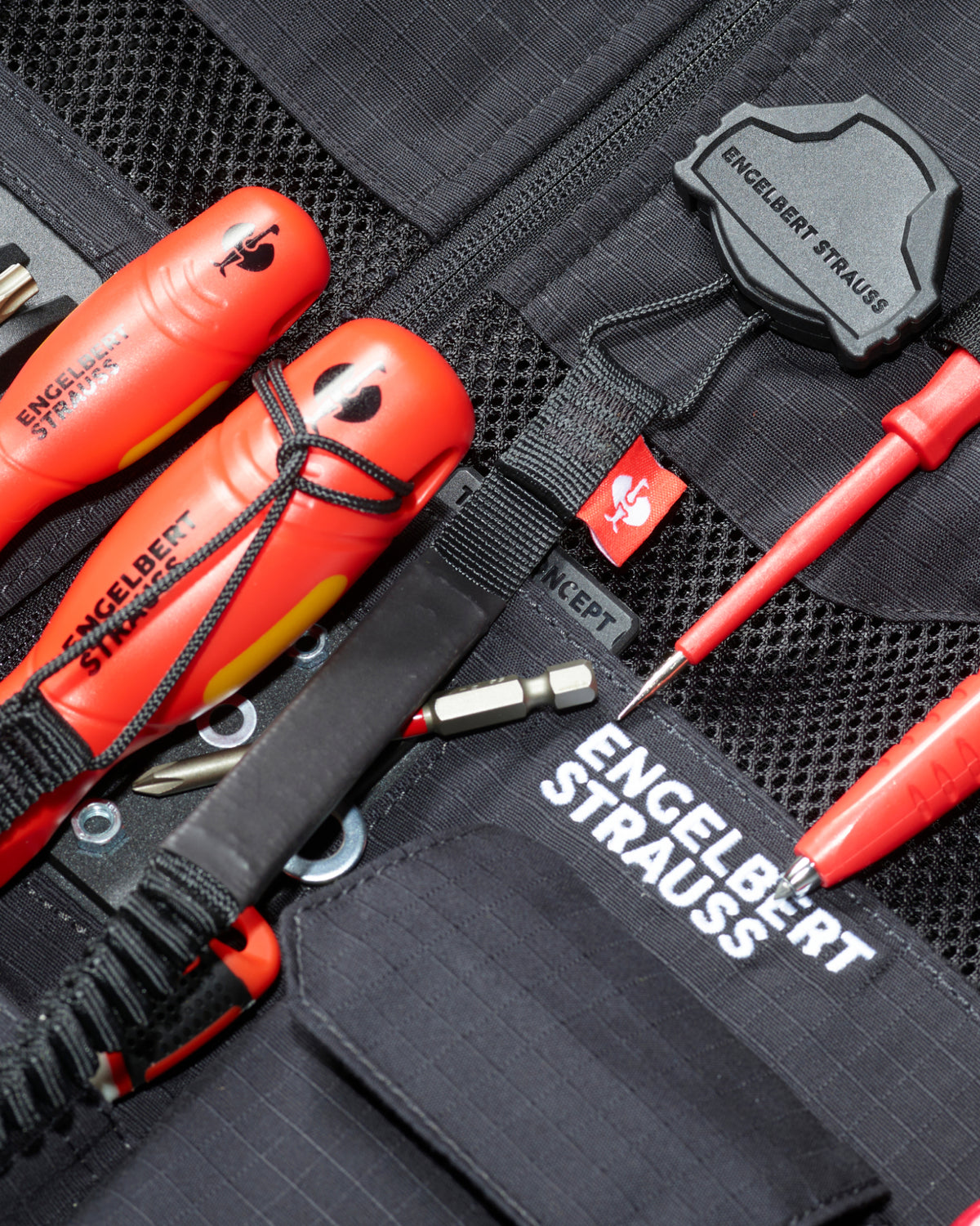A worker uses a black STRAUSS e.s.tool concept tool leash on a modular work belt with utility pants.