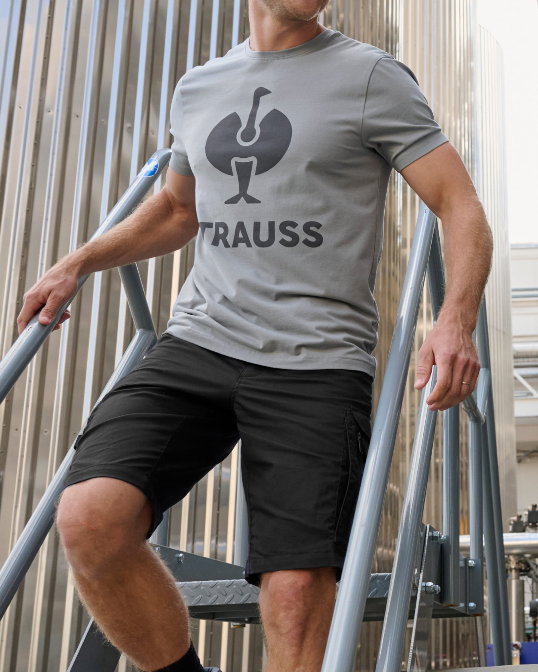 Engelbert Strauss e.s. concrete light shorts in black in an outdoor-style lifestyle view, showing the shorts as part of a functional work outfit.