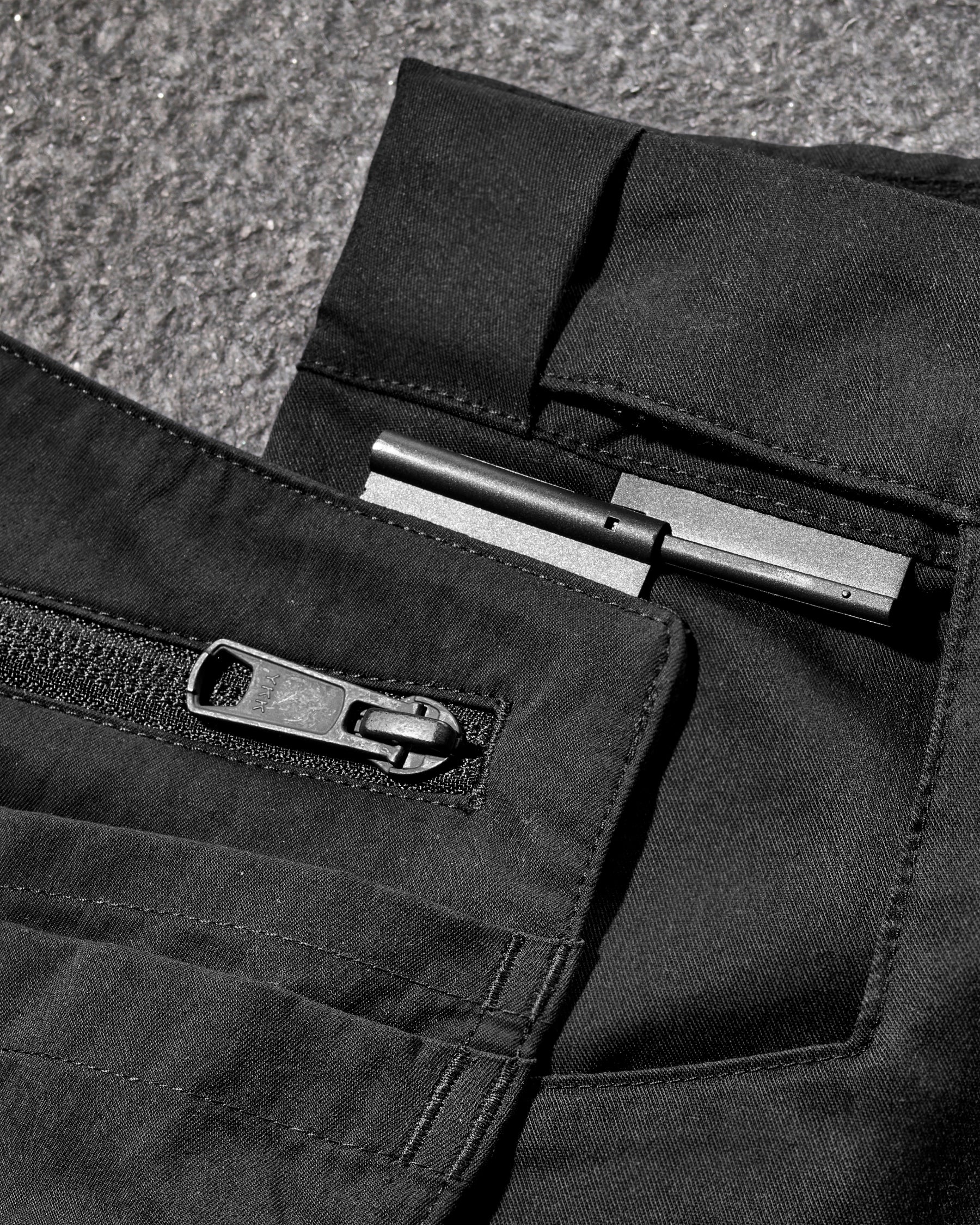 Close-up detail of Engelbert Strauss e.s. concrete light shorts in black, focusing on the utility pocket area, seams, and reinforced workwear construction.