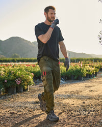 Lifestyle view of Work Pants e.s.concrete light in mud green and stipa green during work