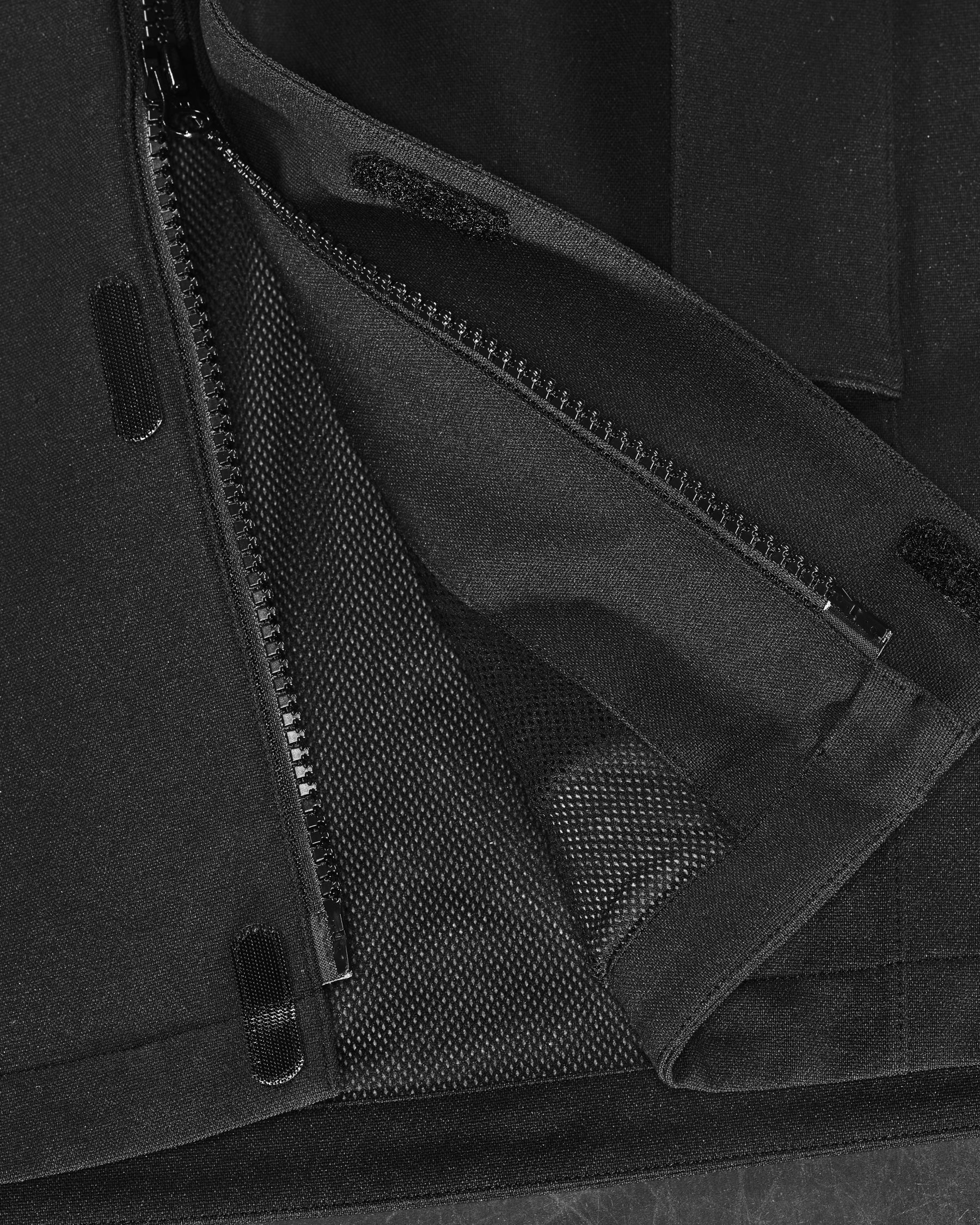 Close-up of zipper and pocket details on STRAUSS e.s.e:pic waterproof rain coat in black