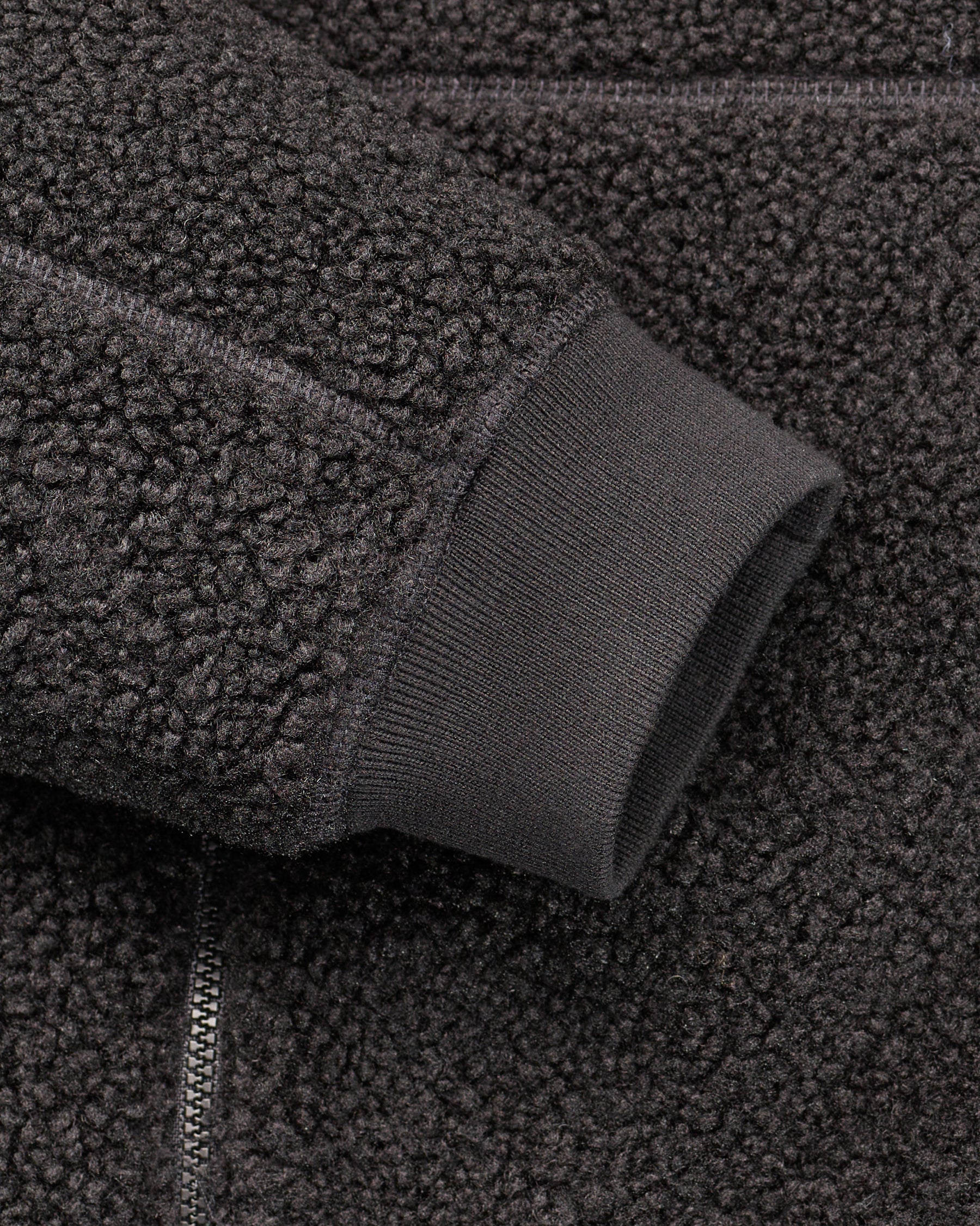 Close-up of zippered pocket details on STRAUSS e.s.e:pic hooded sherpa fleece jacket in black