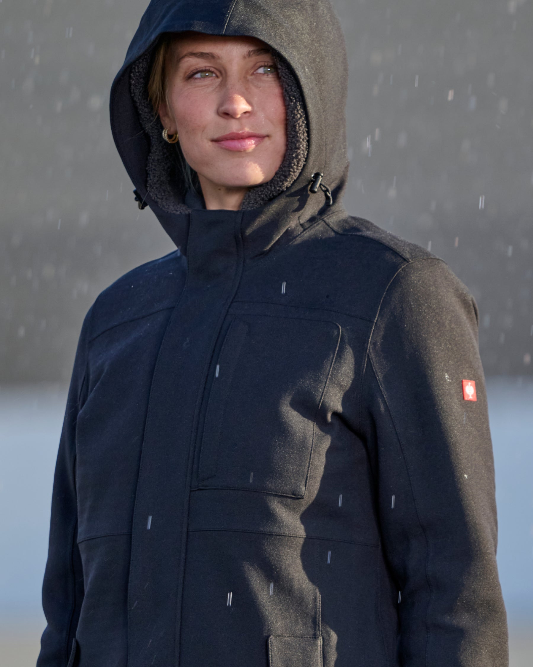 STRAUSS women's e.s.e:pic waterproof rain coat in black shown during outdoor work