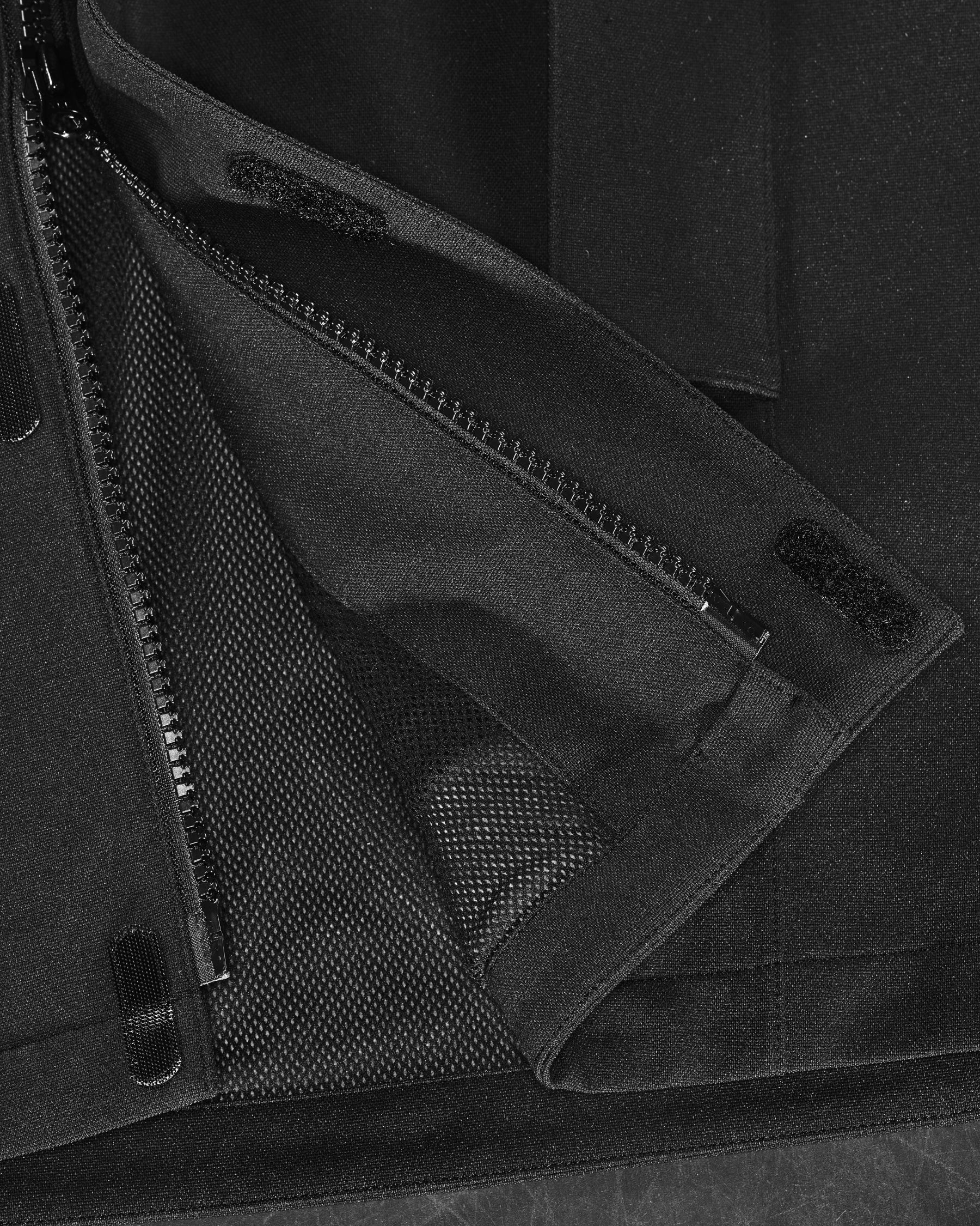 Close-up of zipper and pocket details on STRAUSS women's e.s.e:pic waterproof rain coat in black
