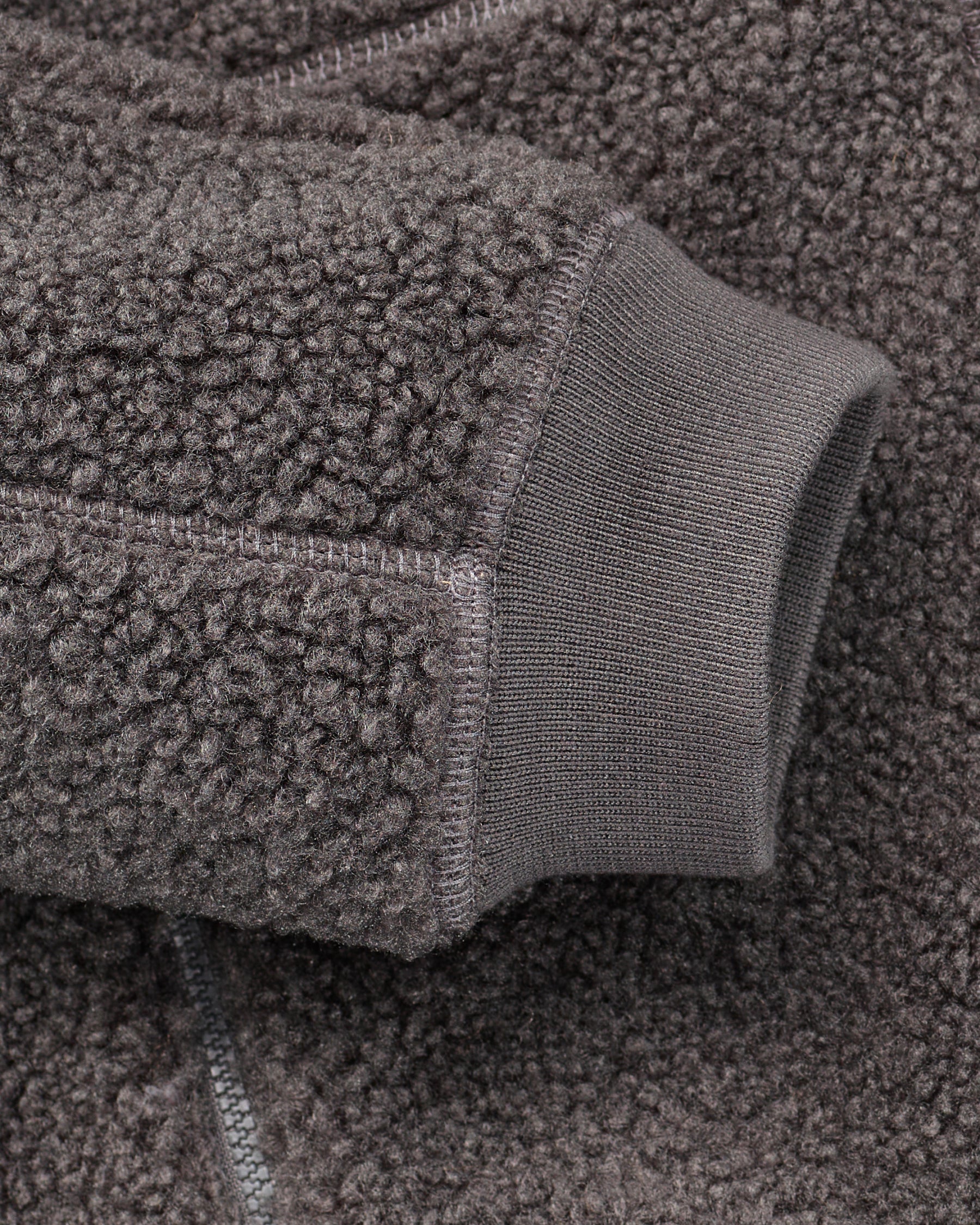 Close-up of zippered pocket details on STRAUSS women's e.s.e:pic hooded sherpa fleece jacket in carbon gray