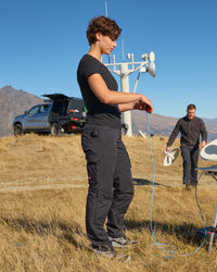 Women's Ripstop Cargo Work Pants e.s.e:pic in black shown in an outdoor workwear setting