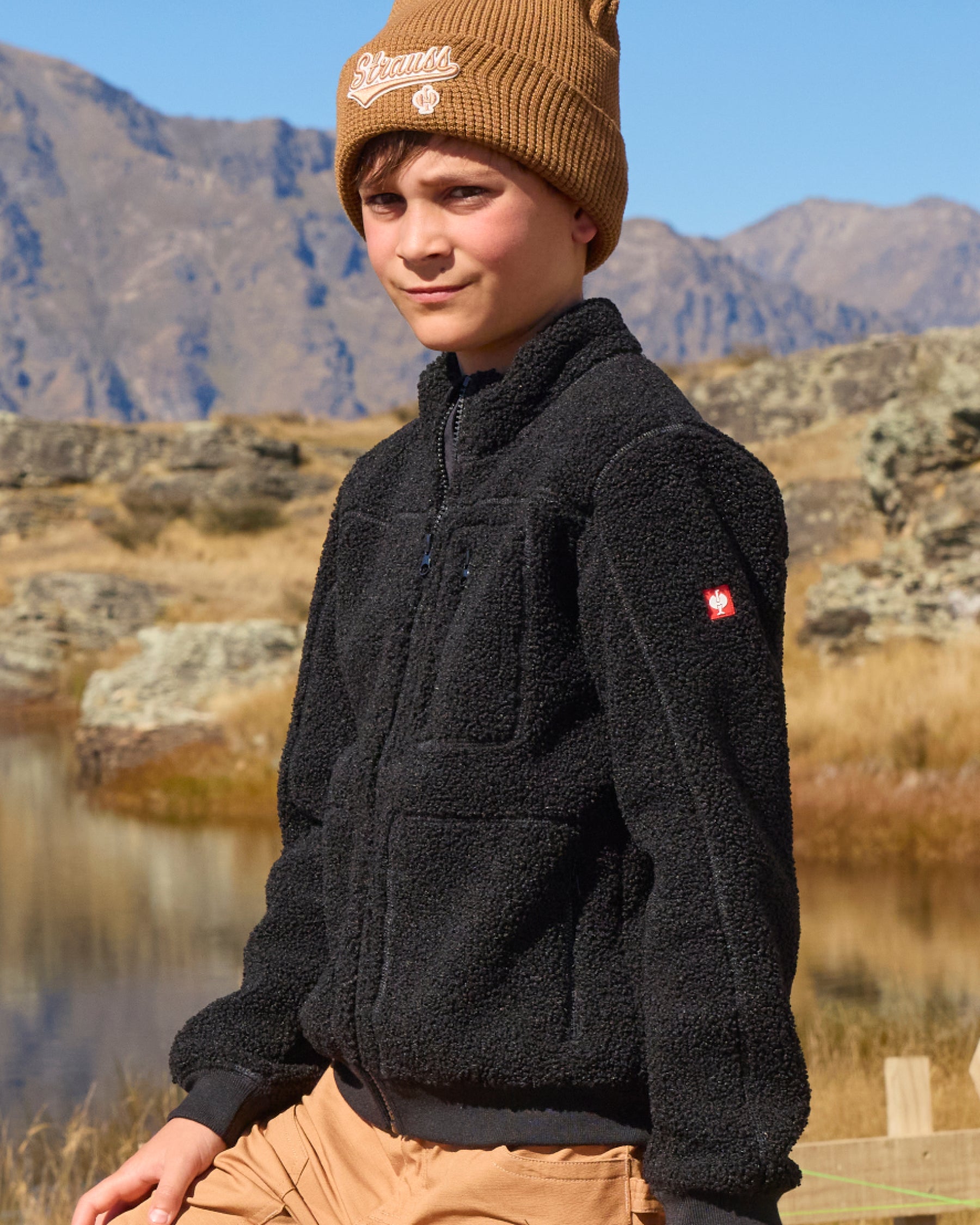 STRAUSS kids' e.s.e:pic sherpa fleece jacket in black worn in a work setting