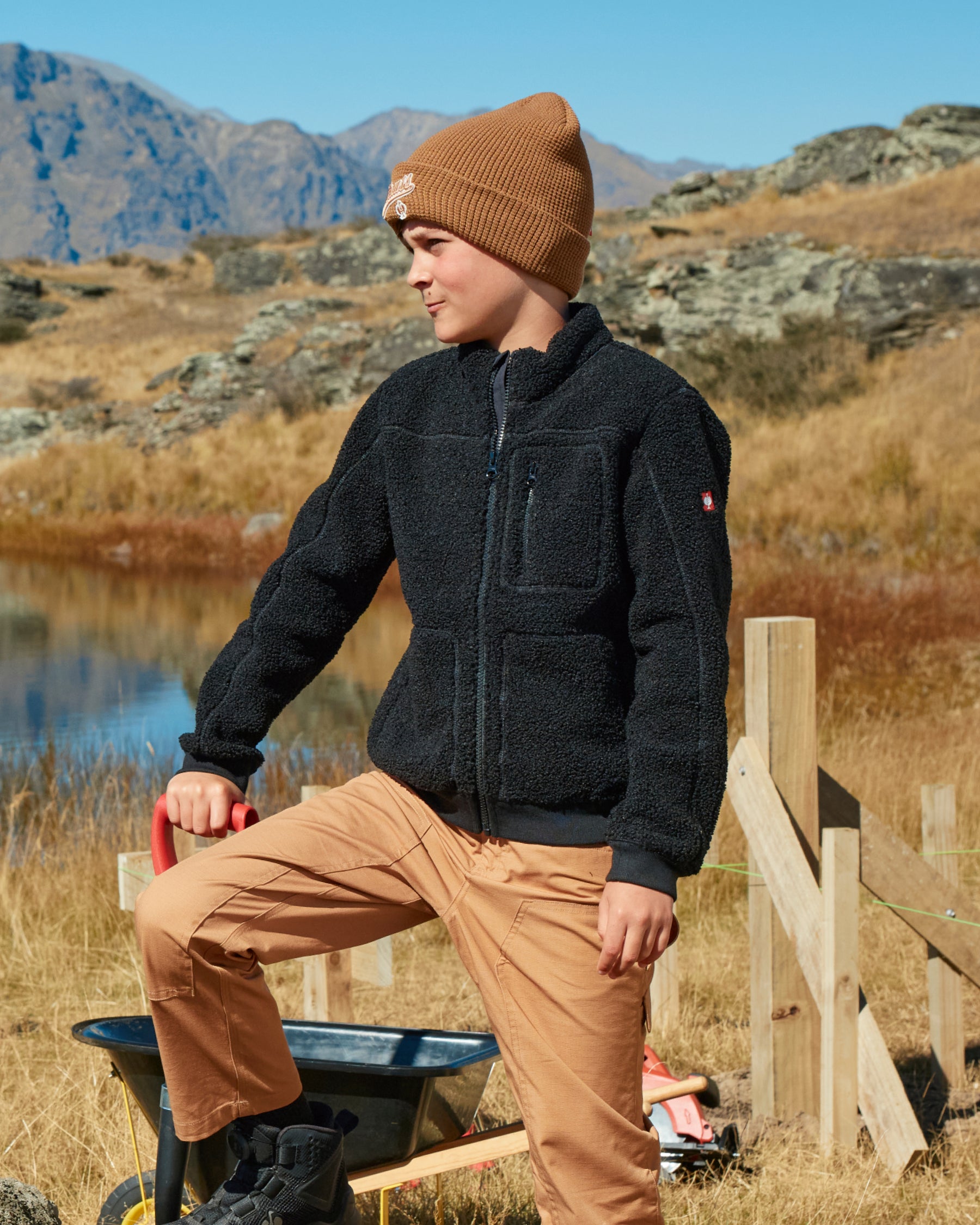 STRAUSS kids' e.s.e:pic sherpa fleece jacket in black shown during outdoor work