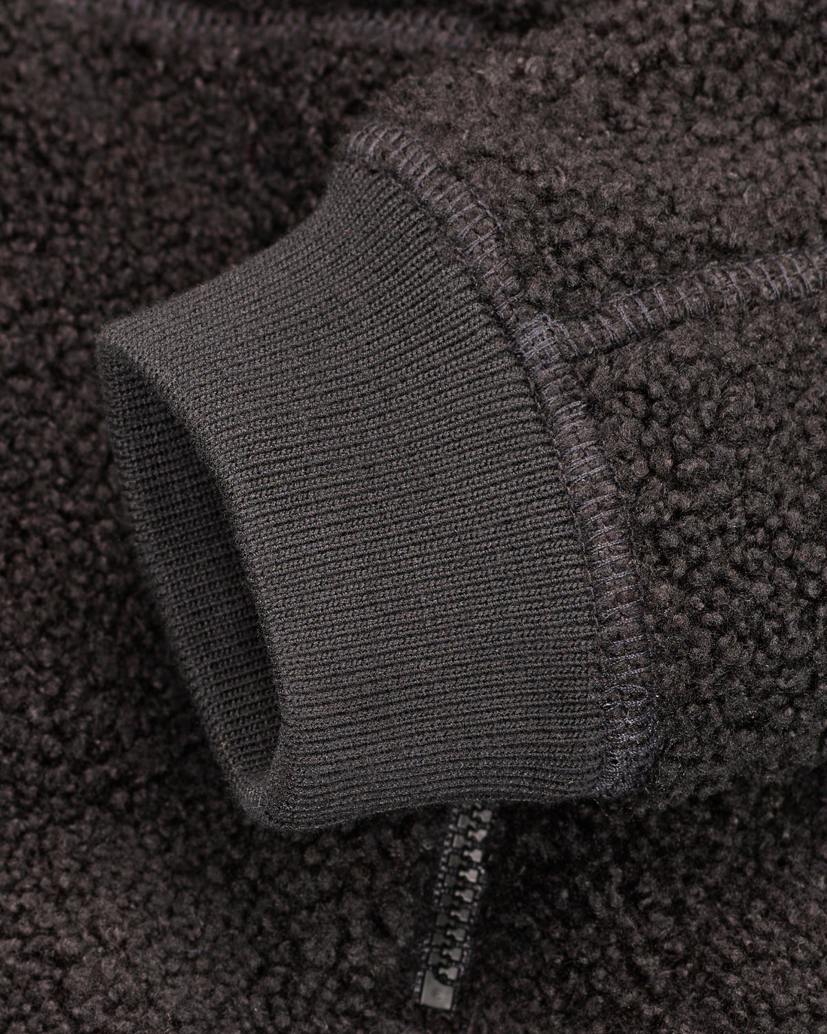 Close-up of zippered pocket details on STRAUSS kids' e.s.e:pic sherpa fleece jacket in black