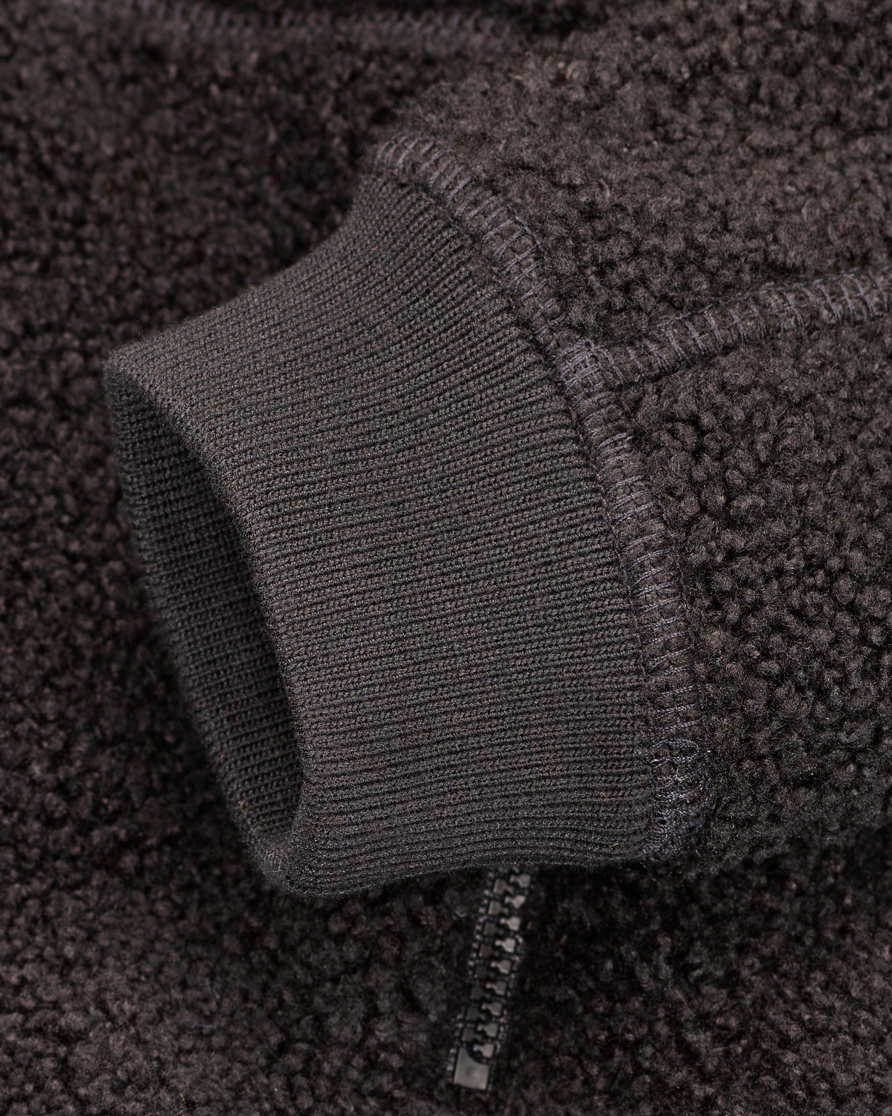 Close-up of zippered pocket details on STRAUSS kids' e.s.e:pic sherpa fleece jacket in black