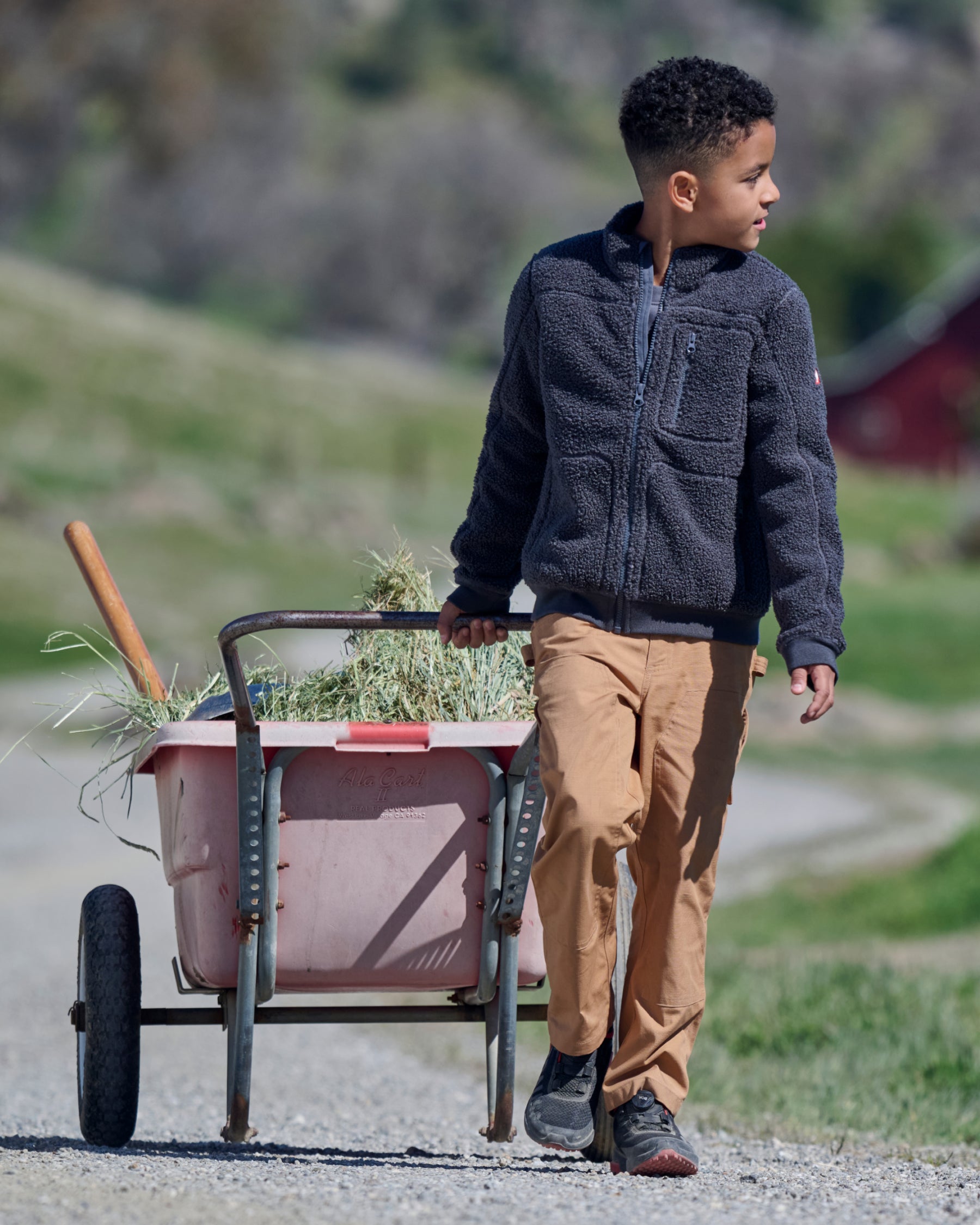 Lifestyle view of Kids' Double Front Ripstop Cargo Pants e.s.e:pic in almond brown during work
