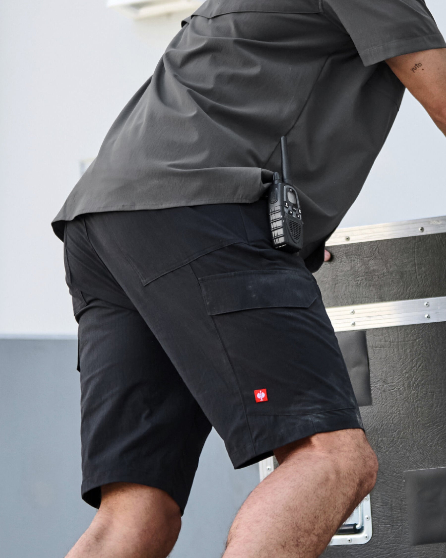 Engelbert Strauss e.s. taktik stretch ripstop cargo work shorts in black in a lifestyle action view, highlighting the practical pocket access and durable workwear silhouette.