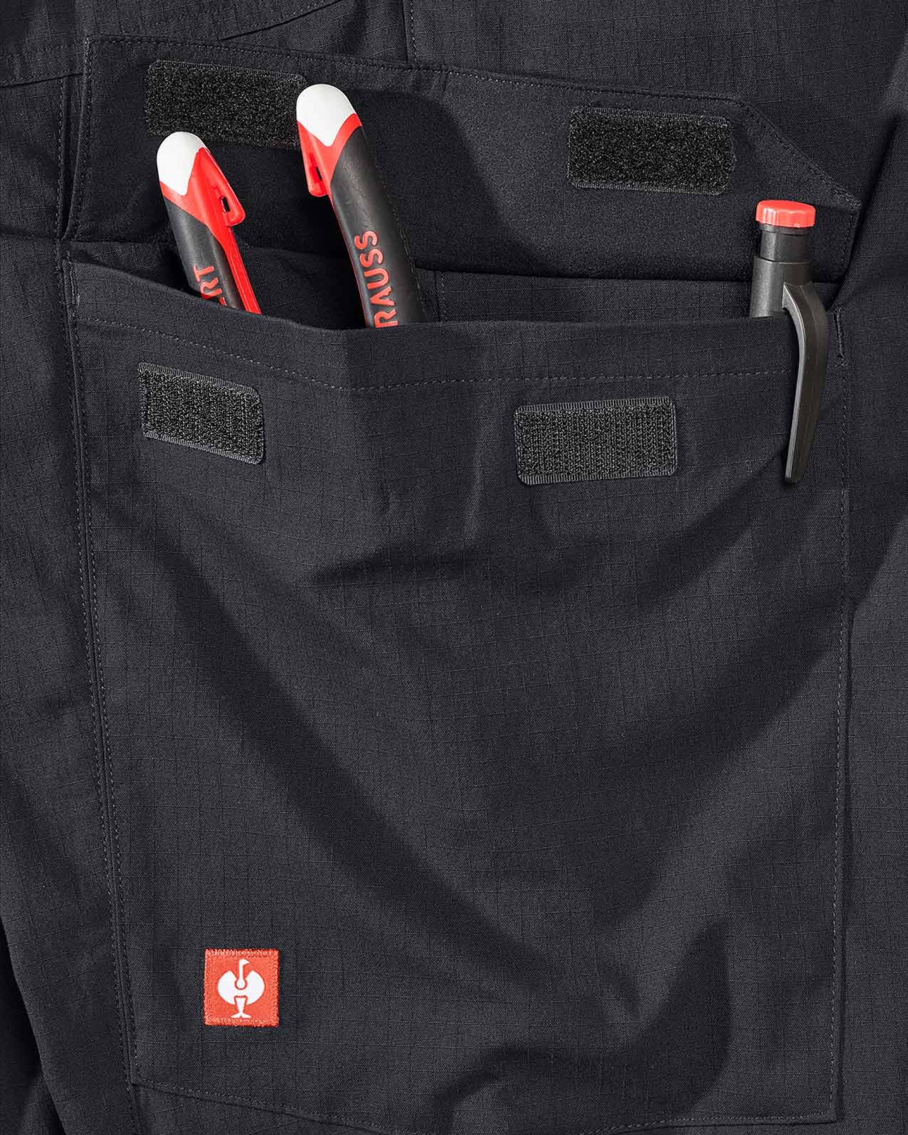 Close-up detail of Engelbert Strauss e.s. taktik stretch ripstop cargo work shorts in black, focusing on the utility pocket area, seams, and reinforced workwear construction.
