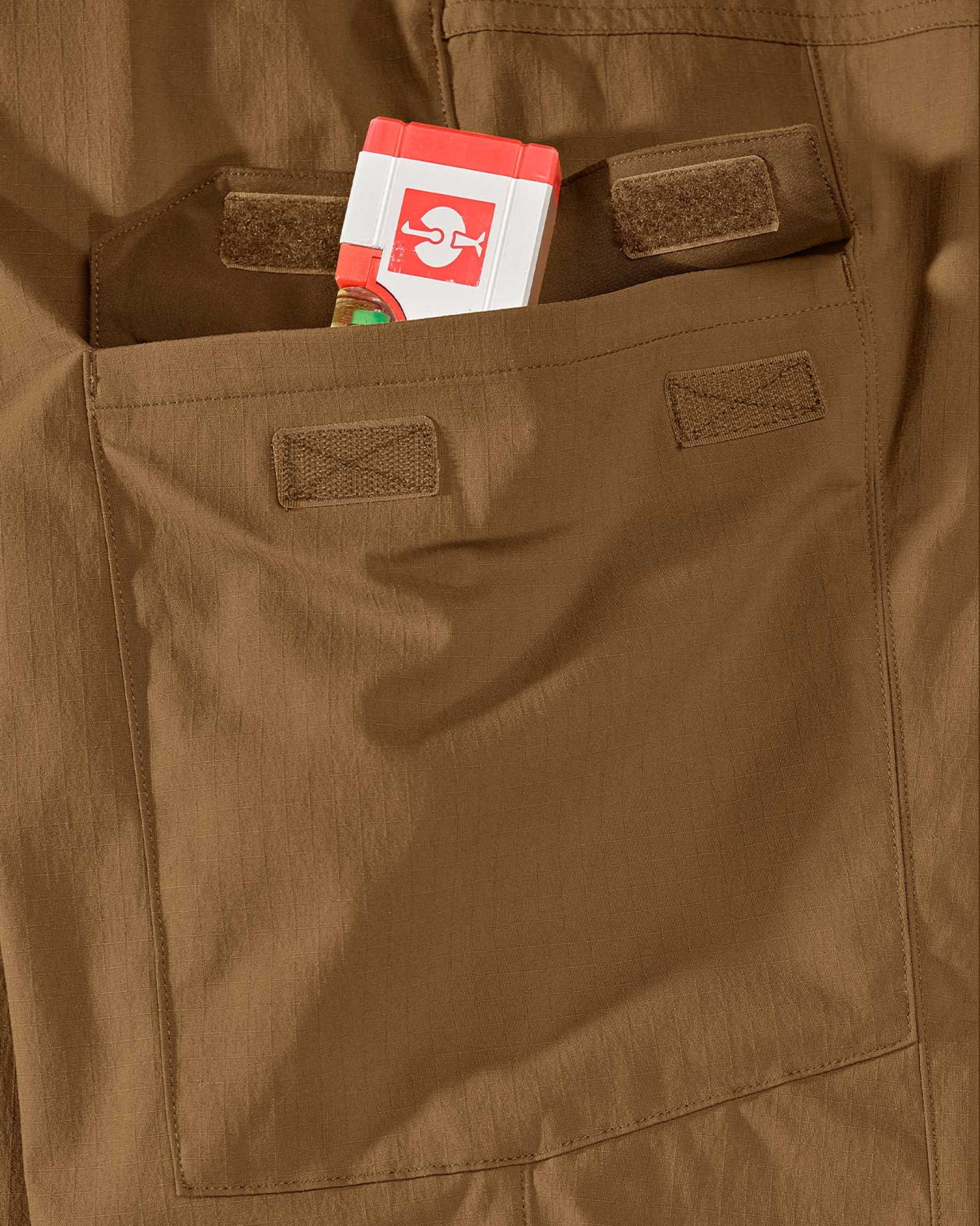 Close-up detail of Engelbert Strauss e.s. taktik stretch ripstop cargo work shorts in desert brown, focusing on the utility pocket area, seams, and reinforced workwear construction.