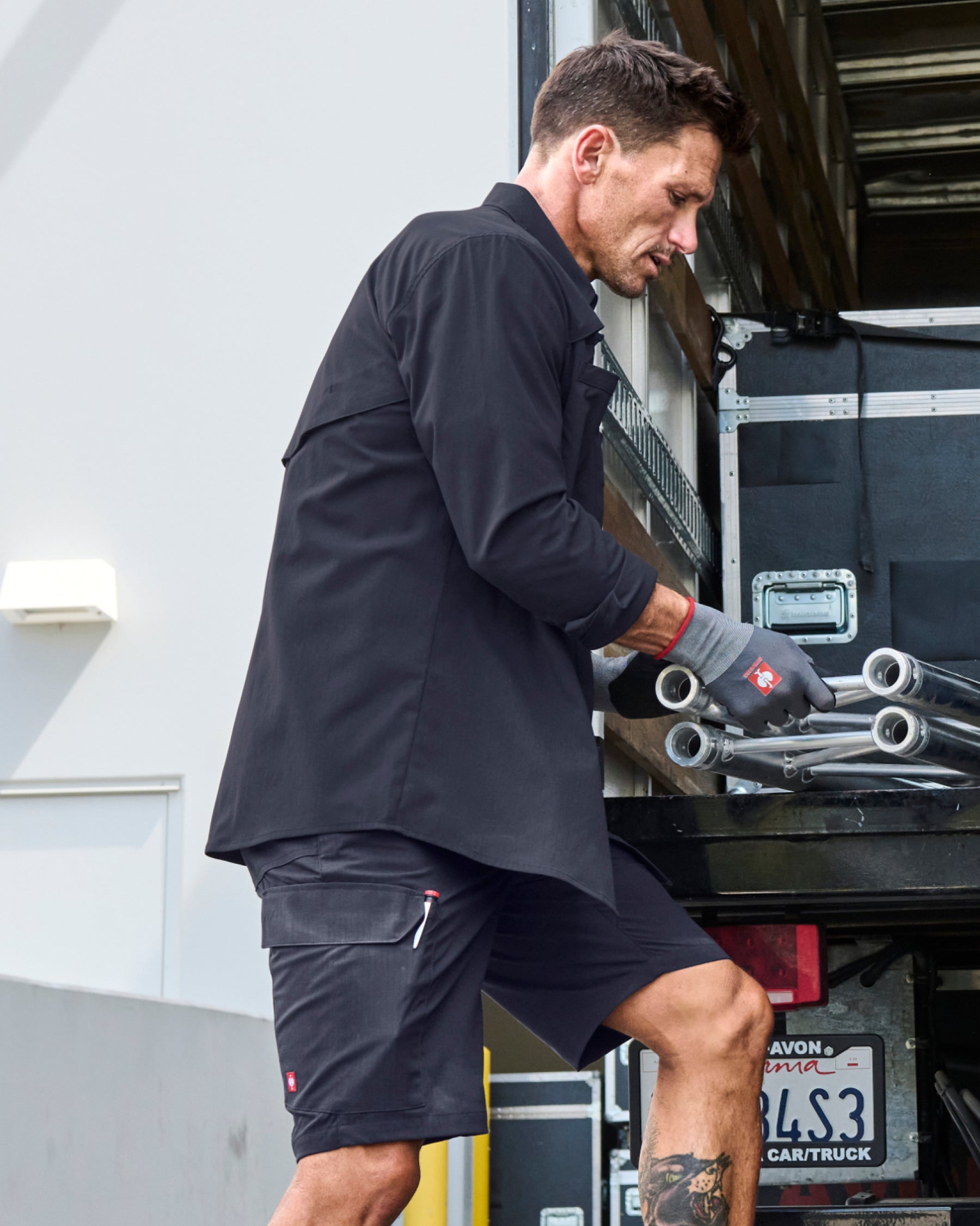 Engelbert Strauss e.s. taktik stretch ripstop cargo work shorts in nero blue in a lifestyle action view, highlighting the practical pocket access and durable workwear silhouette.