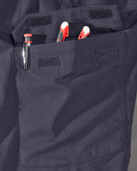Close-up detail of Engelbert Strauss e.s. taktik stretch ripstop cargo work shorts in nero blue, focusing on the utility pocket area, seams, and reinforced workwear construction.