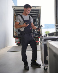 black STRAUSS Stretch Ripstop Cargo Work Bib Overall e.s.taktik worn in a work setting