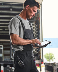 black STRAUSS Stretch Ripstop Cargo Work Bib Overall e.s.taktik worn on the job