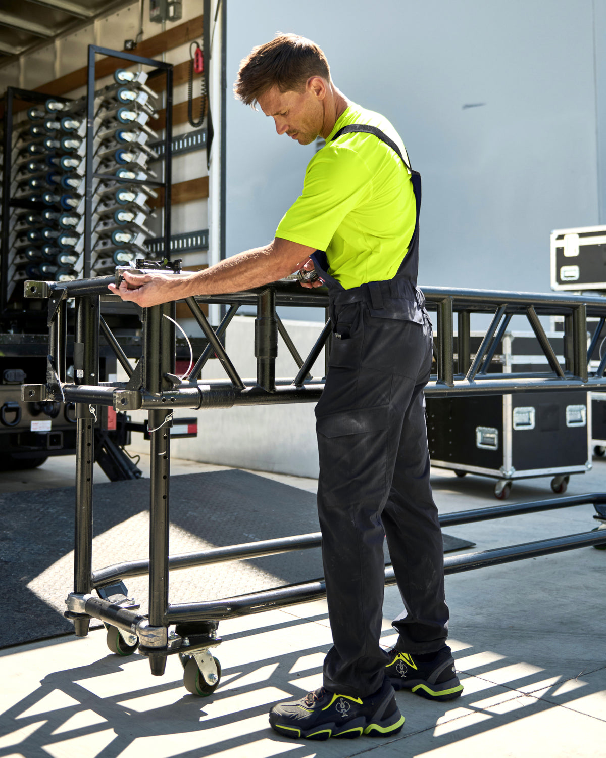 black STRAUSS Stretch Ripstop Cargo Work Bib Overall e.s.taktik shown in use at a jobsite