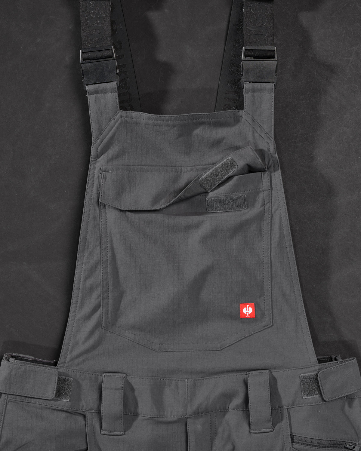 Close-up of carbon gray STRAUSS Stretch Ripstop Cargo Work Bib Overall e.s.taktik seam, hardware, and workwear details
