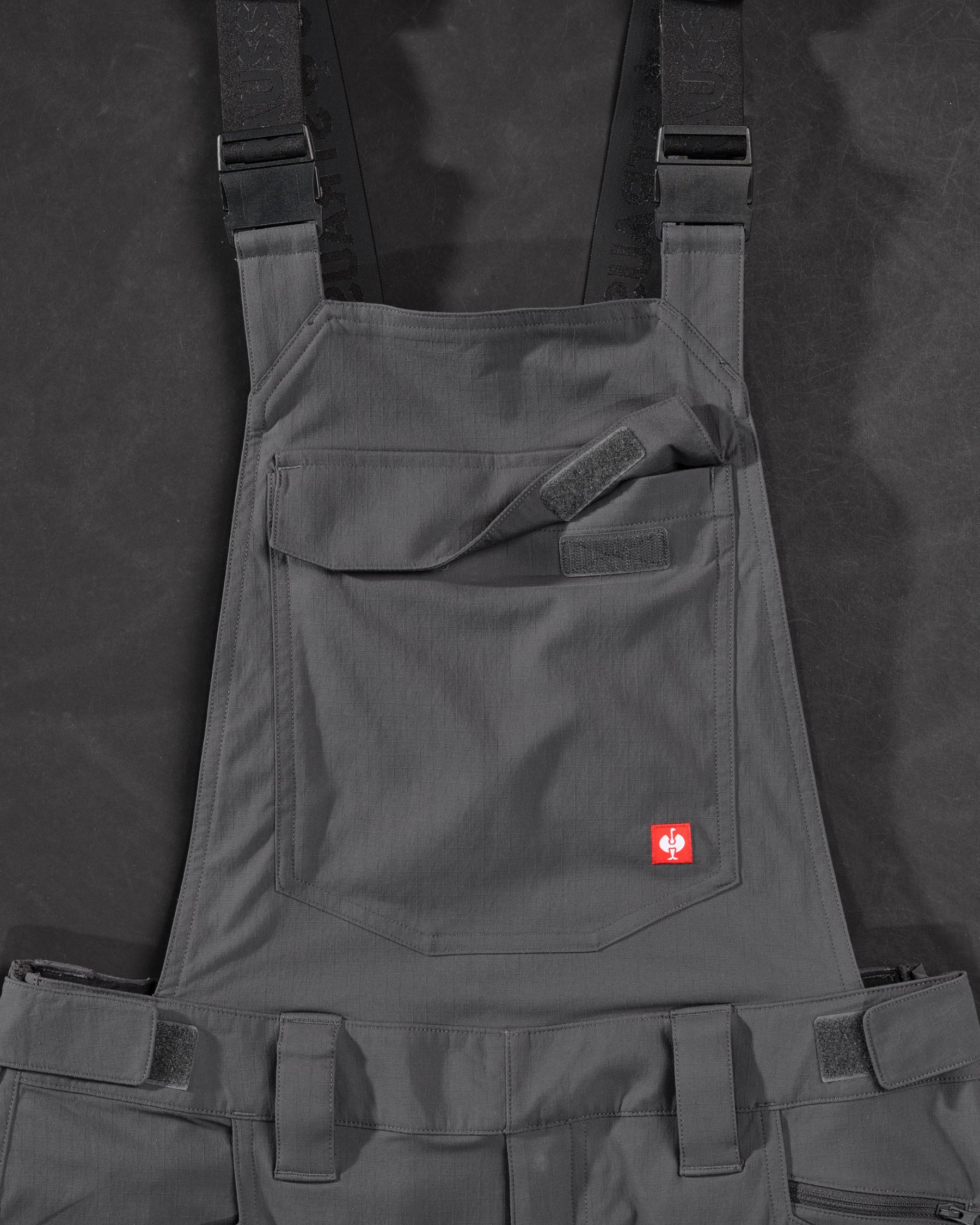 Close-up of carbon gray STRAUSS Stretch Ripstop Cargo Work Bib Overall e.s.taktik seam, hardware, and workwear details